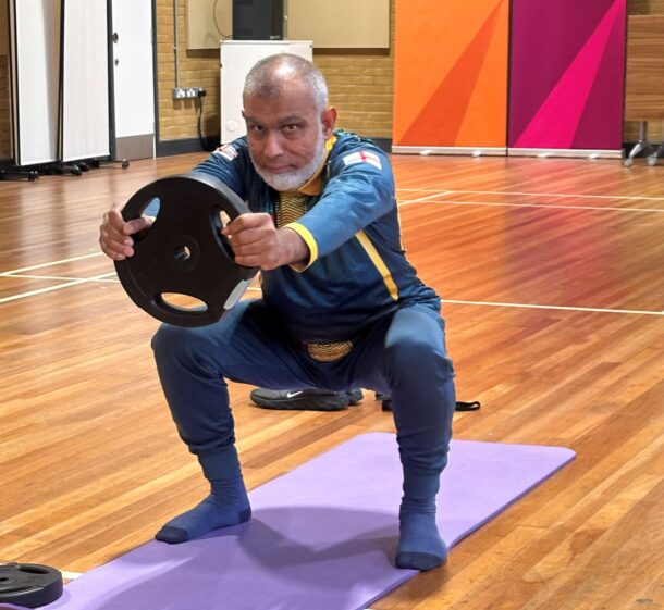 Euston Community Hub user Moksud lifts weights during exercise on a yoga mat