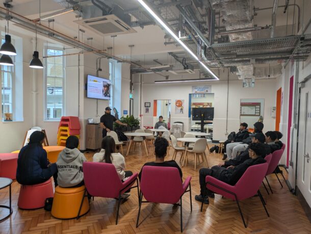 Members of the Fitzrovia Youth in Action group seated in a circle take part in a session at the Euston Community Hub